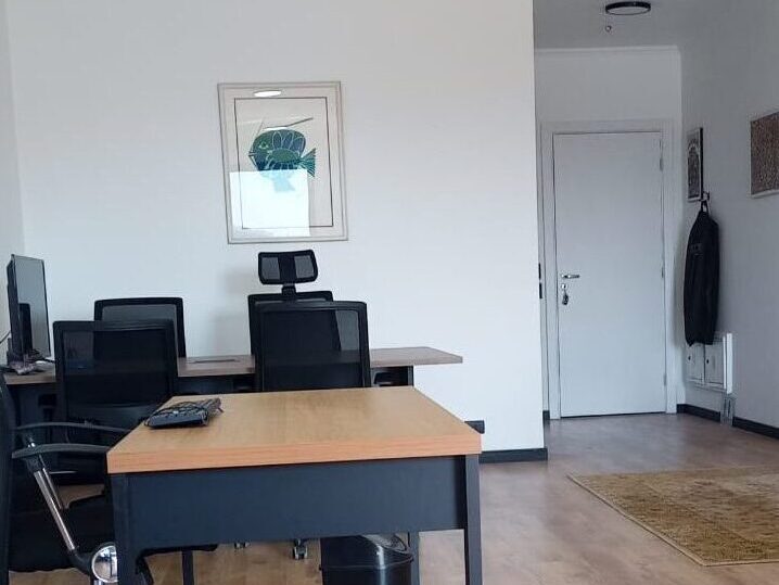 Sala de atendimento do escritório, com estações de trabalho e ambiente organizado