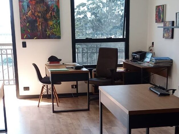 Interior do escritório da Advocacia Toledo Maluf, com mesas de atendimento e ampla iluminação natural